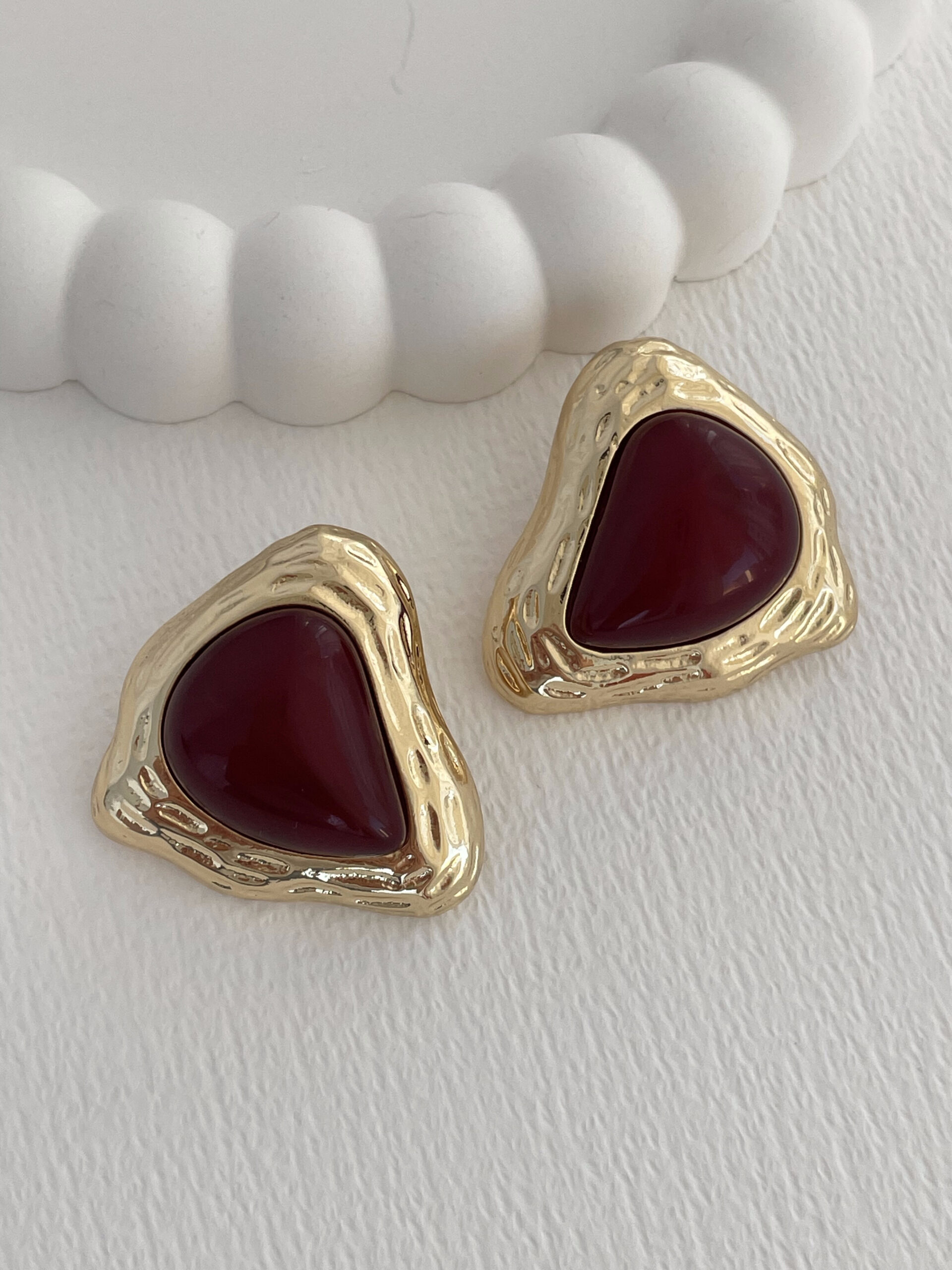 1770297023_0_698496bf3bbb0-1.jpg Özel Seri Desenli Üçgen Tasarım Bordo Mineli Gold Küpe