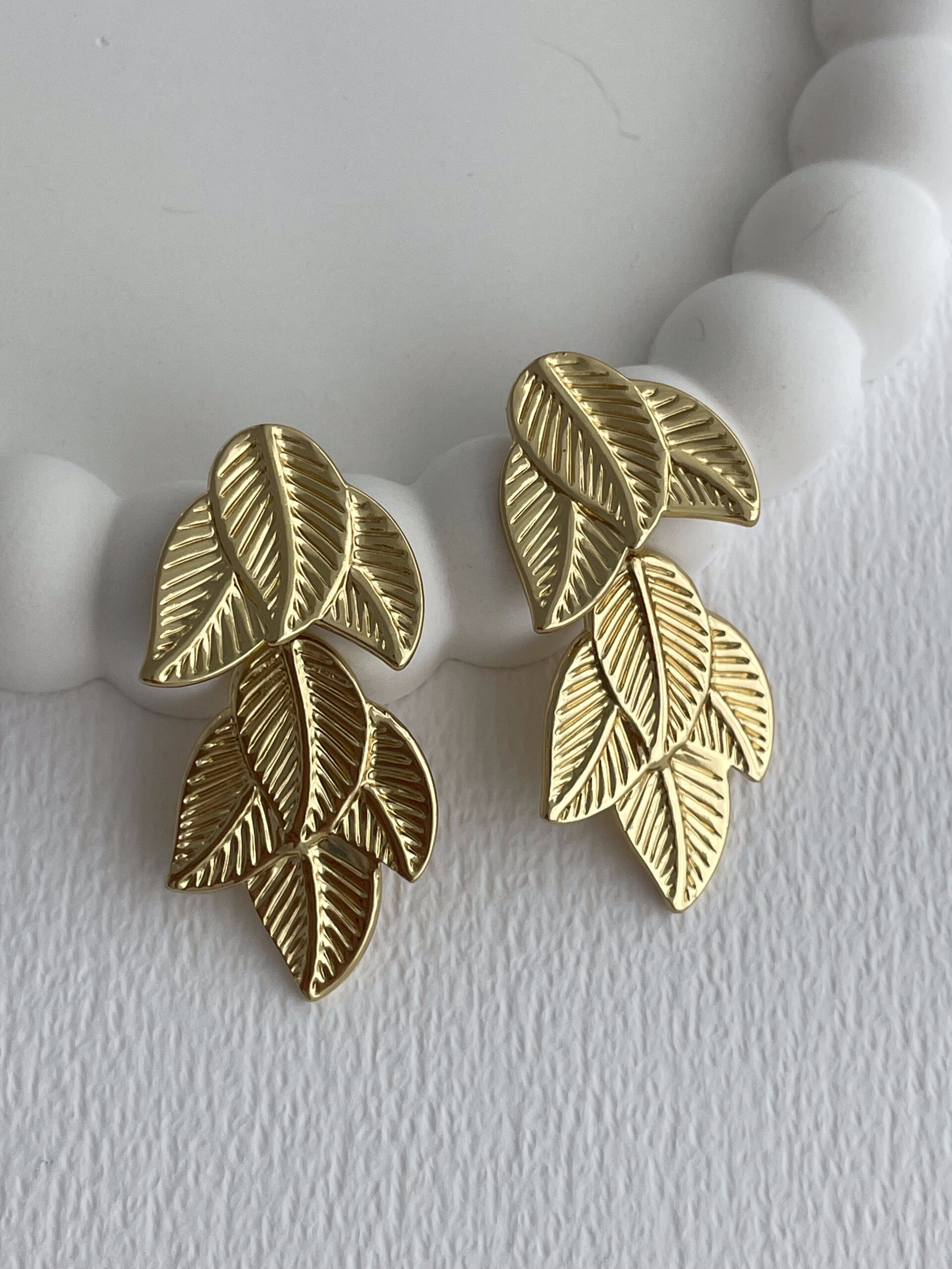 1772112901_0_69a04c052792a.jpg Çelik Desenli Yaprak Tasarım Gold Küpe